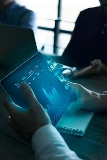 Pessoa analisando dados financeiros em um tablet com gráficos digitais, simbolizando tecnologia e gestão em contabilidade para o terceiro setor.